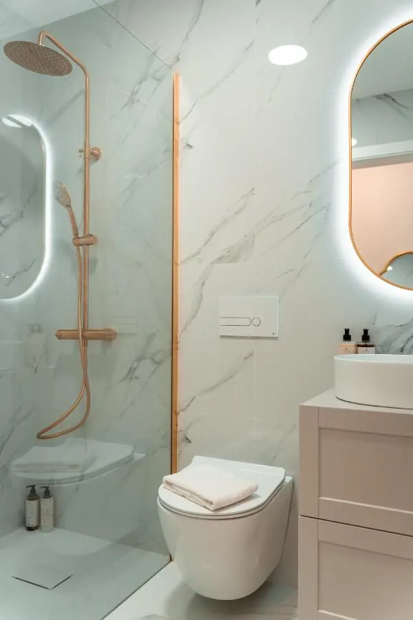Casa de banho do T2 em mármore branco com torneiras em latão escovado